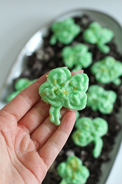 Shamrock Frozen Frosting Bites with Vanilla Frosting close up in hand