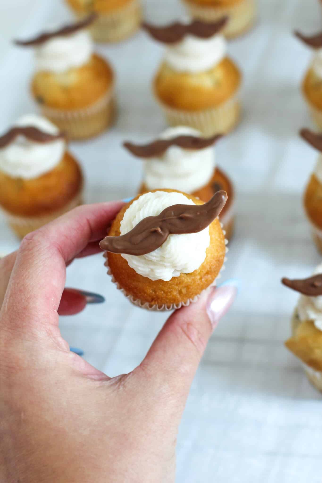 Vanilla Frosting- Mustache Cupcakes close up top view in hand